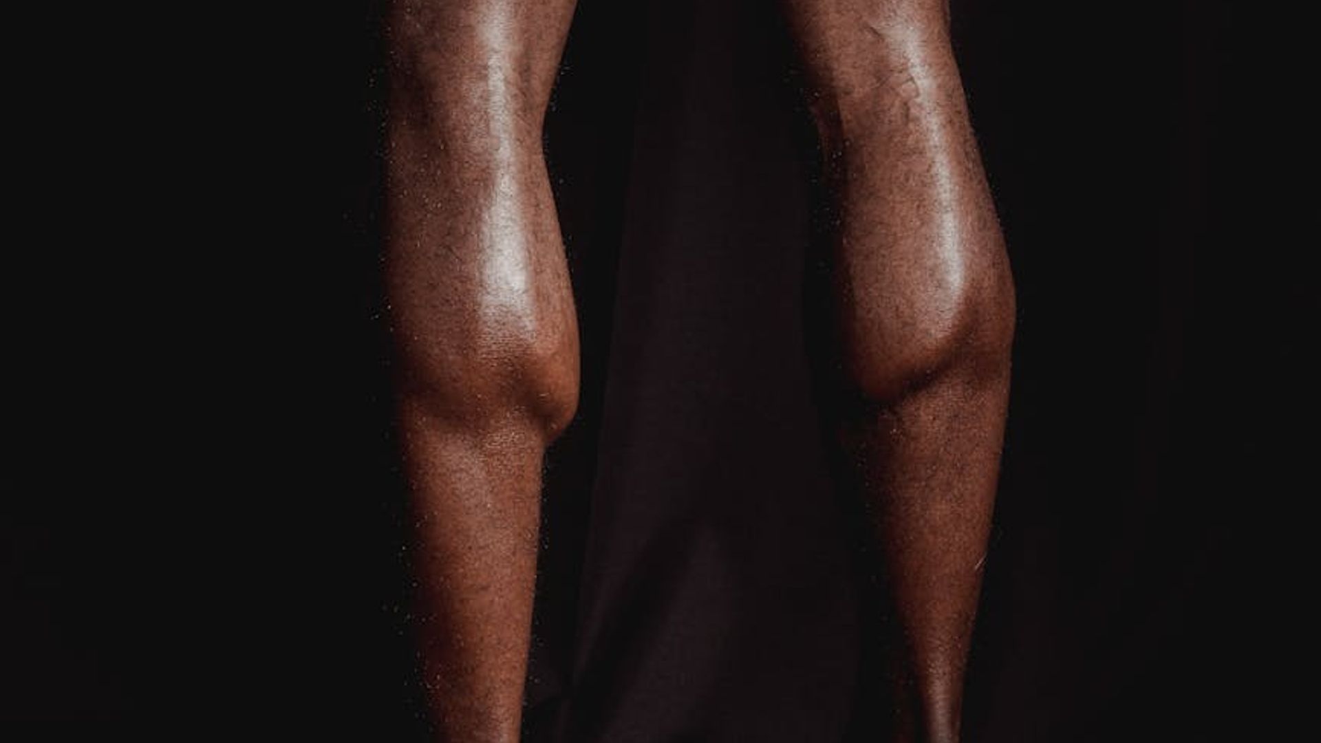 Silhouette of a man in a powerful stance against a dark background.